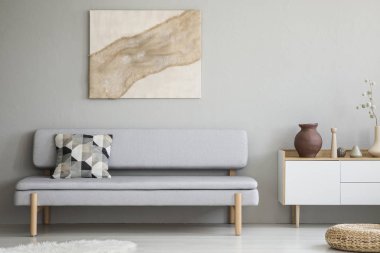 Kanepe yastık modern oturma odası iç ile dolap ile yukarıda gri duvar boyama. Gerçek fotoğraf