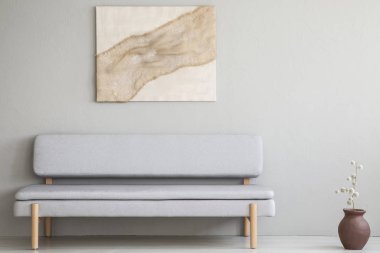 Doğal, çuval bezi artwork en az oturma odası iç basit, gri koltukta yukarıda asılı. Gerçek fotoğraf