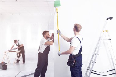 Beyaz boya ustası terbiye ederken yeşil duvar iç