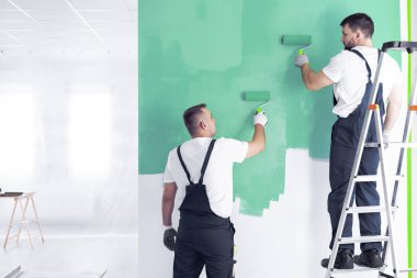Ressam merdiveninde bir meslektaşı ile iç yeniden dekore etmekten iken bir duvar yeşil boyama