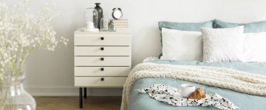 Plaka kupa kahve ve kruvasan ile yatakta gerçek fotoğraf parlak yatak odası iç pastel yatak takımları ile desenli kumaş üzerine yerleştirilir. Plaka üzerinde arka plan bulanık odaklanmak