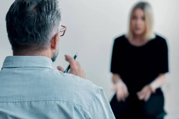 Close Therapist Holding Pen Talking His Blurred Female Patient — Stock Photo, Image