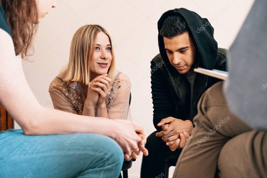 Group of teenagers sitting together and smiling during a support meeting