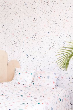 Desenli yatak lastrico çarşaflar ve yastıklar pastel yatak odası iç noktalı bir duvar ile. Gerçek fotoğraf