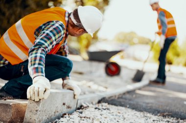 İşçi ile eldiven ve curbs sokakta düzenlenmesi bir kask içinde. Bulanık adam içinde belgili tanımlık geçmiş