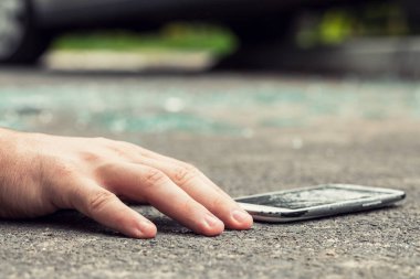 Bir kurban ve smartphone yolda tehlikeli olaydan sonra el Close-up