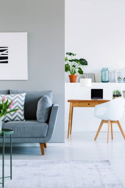Gerçek fotoğraf gri ile modern düz iç kanepe, ahşap masa lambası, mockup bilgisayar ve monstera bitki ile
