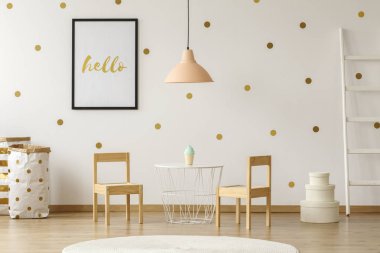 Pastel lamba beyaz masa ve çocuğun oda iç posteri ile ahşap sandalyeler yukarıda. Gerçek fotoğraf