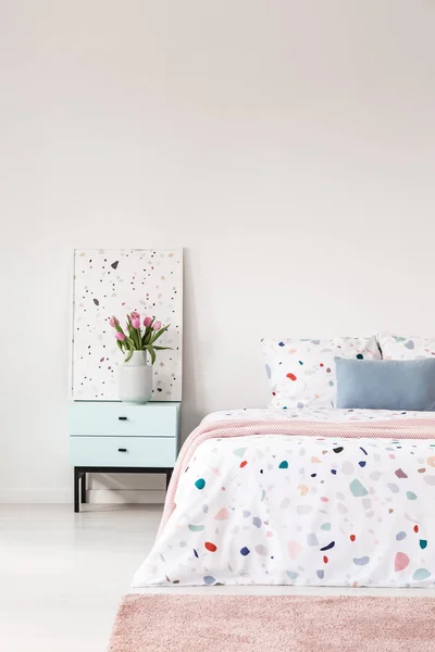 Lastrico シートが付いているベッドの写真をトリミングするには ピンクの敷物と花と寝室のインテリアのグラフィックの花瓶付きベッドサイド テーブル 空の壁 あなたのポスターのための場所 — ストック写真