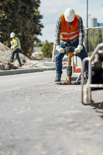 Trabajador Casco Chaleco Reflectante Con Taladro Reparando Asfalto — Foto de Stock