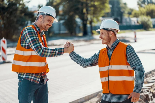 Lavoratori Sorridenti Giubbotti Riflettenti Caschi Bianchi Che Salutano — Foto Stock