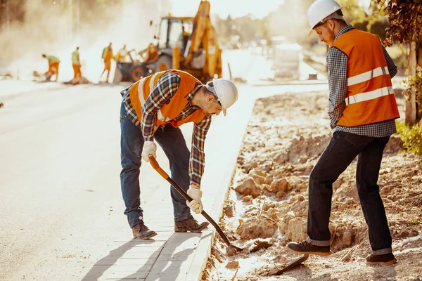 Trabajadores Con Chalecos Reflectantes Que Utilizan Palas Durante Trabajo Calzada —  Fotos de Stock