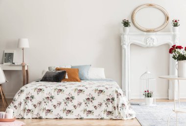 Desenli yastıklar beyaz yatak odası iç ayna ile Yataklı yanındaki masa lambası. Gerçek fotoğraf