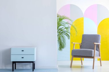 Bir geniş, pastel ofis iç nane dolap konumu houndstooth desenli koltuk yanında kopya alanı ile beyaz duvar karşı olan gerçek fotoğraf