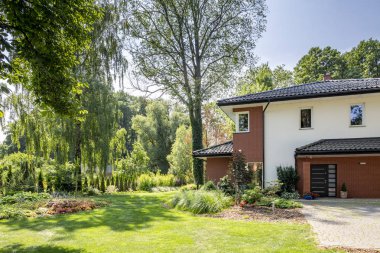 Ağaçlar ve pencere ve kapı ile modern ev bahçe doğal görünümünü