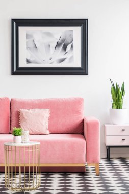 Poster pembe bitki altın tablo ile modern oturma odası iç koltukta yukarıda. Gerçek fotoğraf
