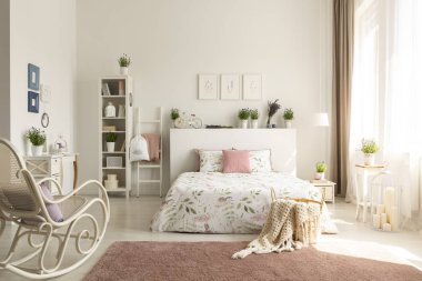 White bedroom interior with dirty pink carpet, rocking chair, window with drapes and king-size bed in the real photo clipart