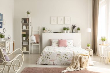 Sepet ayakta parlak kadınsı yatak odası iç kral yatak, dekor, taze lavanta ve basit posterler gerçek fotoğraf kirli pembe halı üzerinde battaniye örgü