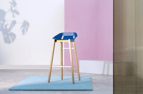 Real photo of a wooden bar stool with a blue seat standing on a piece of plywood in pastel pink studio interior with white accents