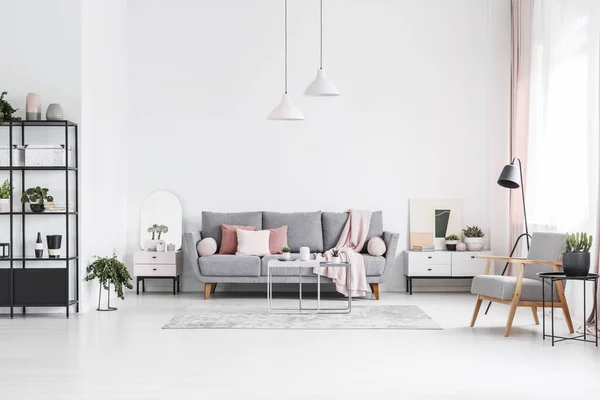 花纹木扶手椅在白色客厅内部与粉红色枕头在灰色沙发上 真实照片 — 图库照片