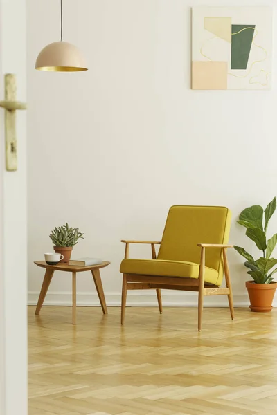 Gelber Sessel Und Couchtisch Mit Tasse Und Pflanze Auf Fischgrätparkett — Stockfoto