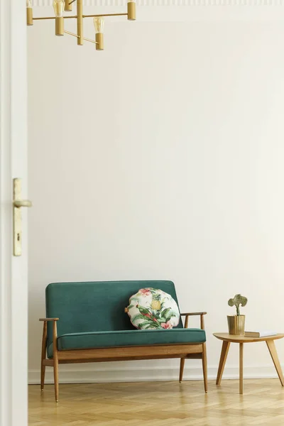 花图案枕头在复古风格 绿色沙发和一个木桌在一个简约的客厅内部与白色墙壁和人字地板 真实照片 — 图库照片