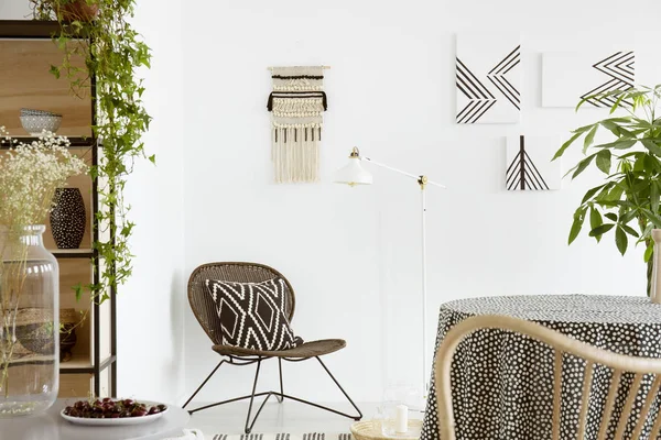 椅子とポスターと白い自由奔放に生きるリビング ルームのインテリアにテーブルの上の植物模様のクッション 実際の写真 — ストック写真