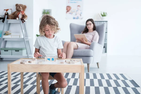 Jongen Zit Aan Tafel Spelen Met Bouwstenen Terwijl Zijn Raadgever — Stockfoto