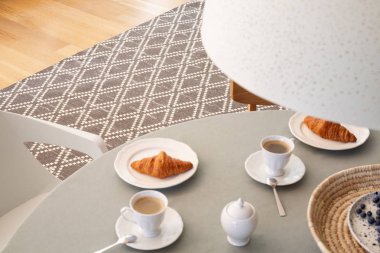 Yüksek açı bardak ve kruvasan SCANDI yemek odası iç gri tablo. Gerçek fotoğraf