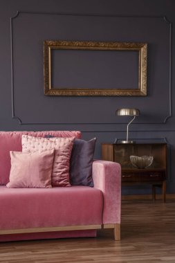 Pembe kanepe oturma odası iç mockup ile altın lamba ile ahşap dolap yanında. Gerçek fotoğraf