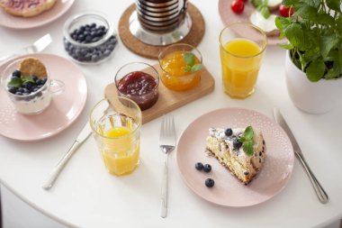 Yüksek açı tatlı, portakal suyu ve marmelat kahvaltı sırasında tablo. Gerçek fotoğraf