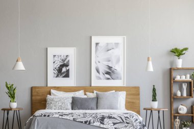 Posterler gri yatak odası iç lambalar ile bitkilerde ile tablolar arasında ahşap yatak yukarıda. Gerçek fotoğraf