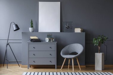 Koltuk yanındaki gri oturma odası iç mockup poster ve lamba ile dolapta. Gerçek fotoğraf