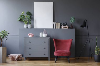 Gri kabine oturma odası iç mockup bitki ve poster ile yanındaki kırmızı sandalye. Gerçek fotoğraf