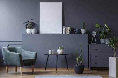 Tablo ve bitki gri oturma odası iç mockup poster ile yanındaki yeşil koltuk. Gerçek fotoğraf