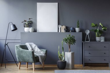 Yeşil tekli siyah lamba ve gri renkli düz poster mockup ile iç bitkiler arasında. Gerçek fotoğraf