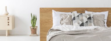 Çift kişilik yatak ile Ahşap karyola ayakta beyaz yatak odası iç taze bitki ile gerçek fotoğraf