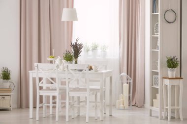 Lamba bitkiler ve perdeler ile pembe yemek odası iç tablo ve beyaz koltuklarda yukarıda. Gerçek fotoğraf