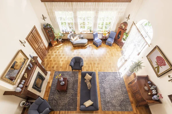 豪华高天花板起居室内的高级房 钴蓝色扶手椅和沙发前面的壁炉 沙发和其他家具在实木复合地板 真实照片 — 图库照片
