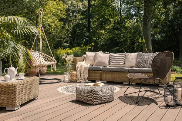 在阳光明媚的花园里的木制甲板上 包括沙发 桌子和椅子的藤露台套装 — 图库照片