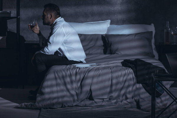 Грустный мужчина после развода пьет алкоголь. Проблема с зависимостью
