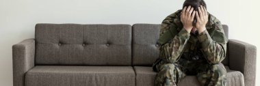 Onun için bir psikoterapist ile onun randevu bekleyen asker üniformalı bir kanepede oturuyor