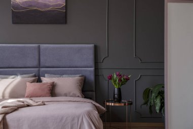 Pastel yatak odası iç yatak kalıplama ve poster ile gri duvara yanındaki lale ile sofistike