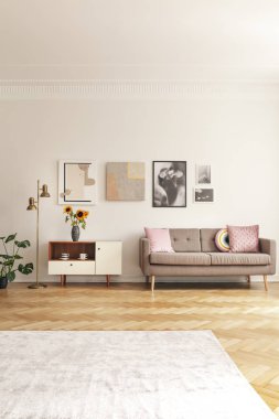 Çiçekler beyaz dolap koltuk aydınlık oturma odası iç pembe yastık ile yanında tarih. Gerçek fotoğraf