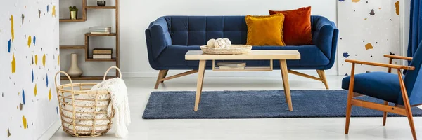 在蓝色沙发前面的木桌全景在五颜六色的平的内部与扶手椅 真实照片 — 图库照片