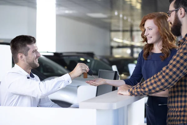 Bilhandlare Som Ger Bilnycklar Till Ett Lyckligt Par Bil Utställningslokal — Stockfoto
