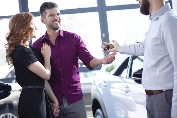 Sorrindo Casal Recebendo Chaves Carro Revendedor Showroom — Fotografia de Stock