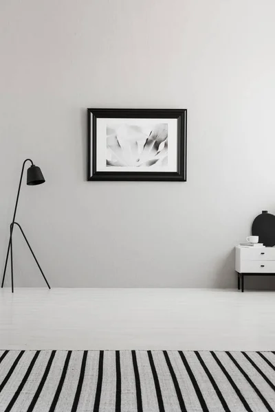 在起居室的灰色墙上贴着条纹地毯和黑灯的海报 真正的照片 您的沙发位置 — 图库照片