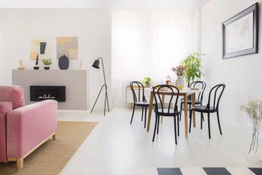 Siyah beyaz daire iç şöminenin yanında lambalı ahşap masa sandalyeler. Gerçek fotoğraf