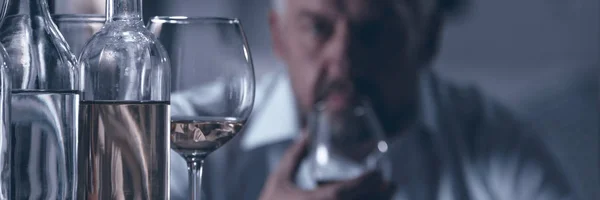 Panorama Van Glazen Flessen Met Alcohol Een Man Onscherpe Achtergrond — Stockfoto